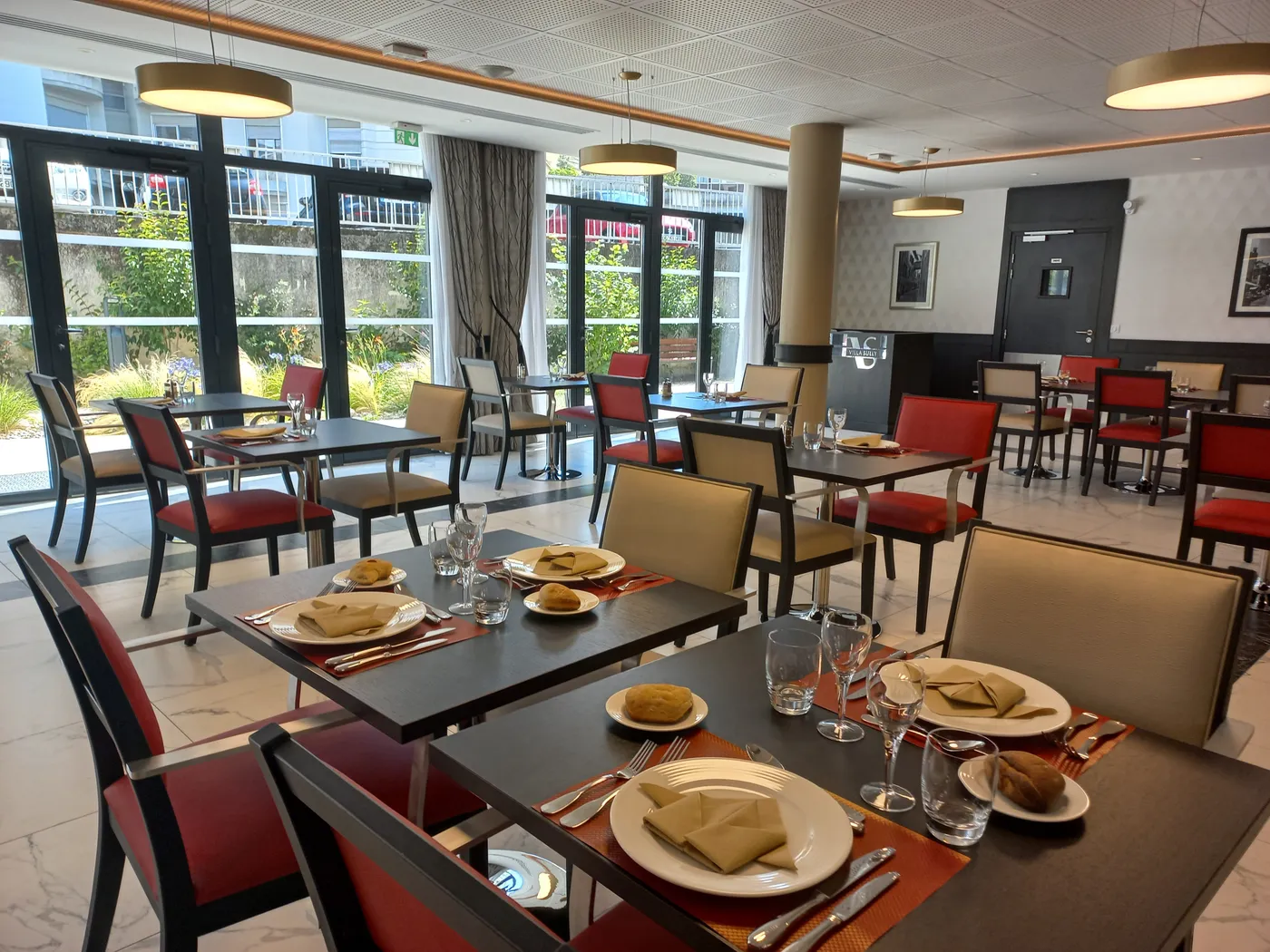 Salle de restaurant lumineuse de la résidence seniors OBEO à Chambéry, tables dressées face aux baies vitrées ouvrant sur le jardin