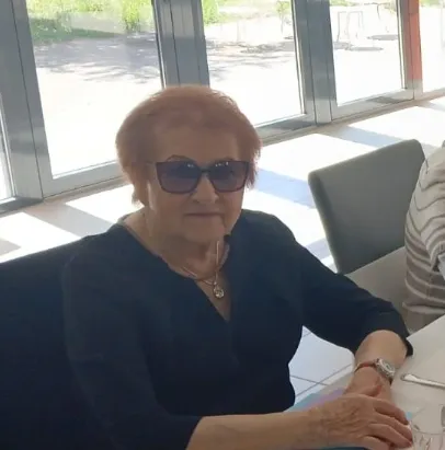 A resident in dark glasses seated at the table in front of the bay window
