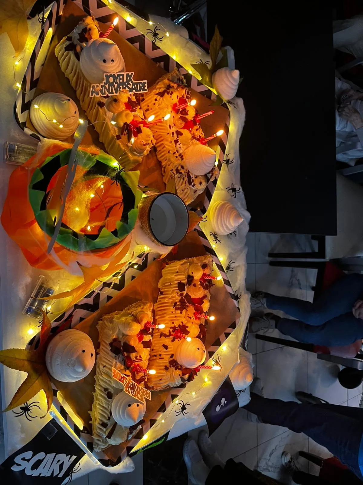 Le buffet d'anniversaire décoré de guirlandes lumineuses et de décorations orange d'Halloween