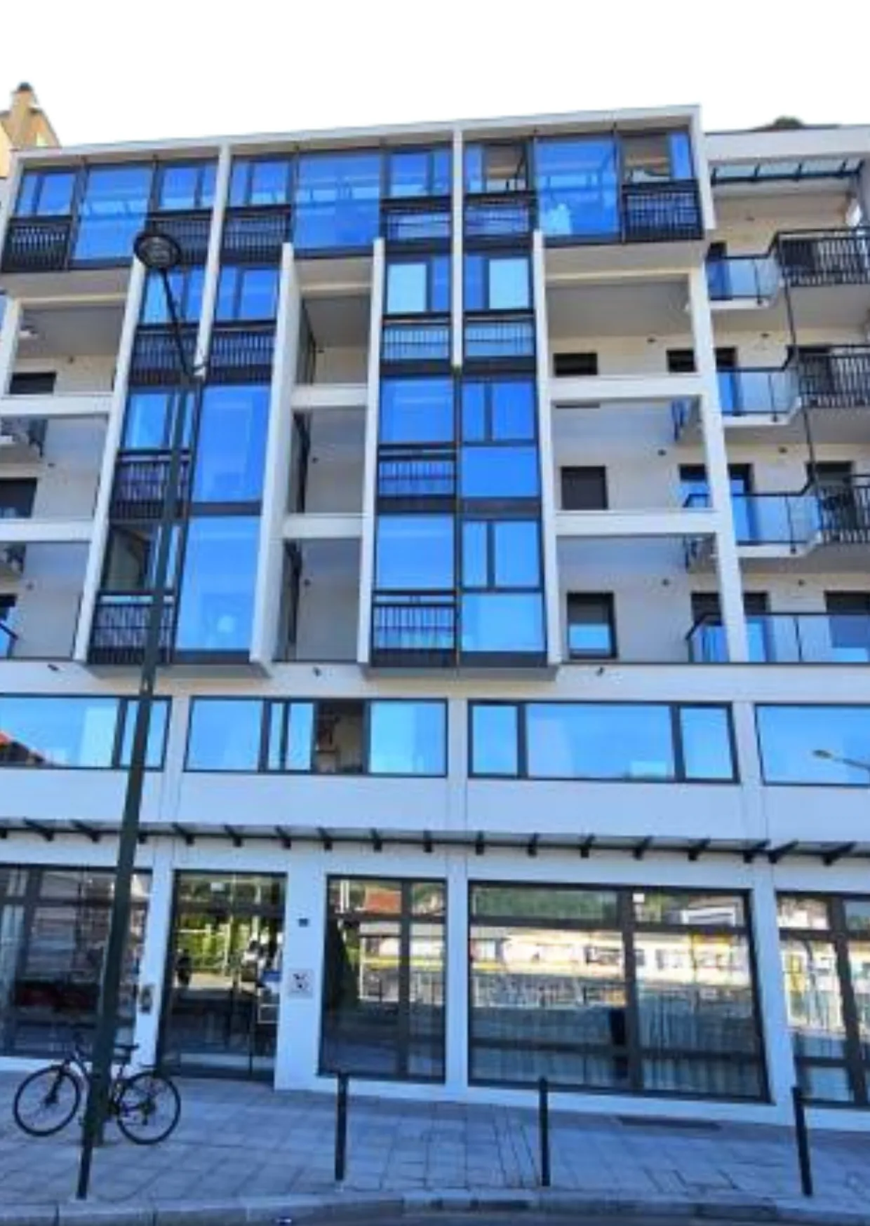 The glass-fronted facade of the Aix-les-Bains residence seen from the street