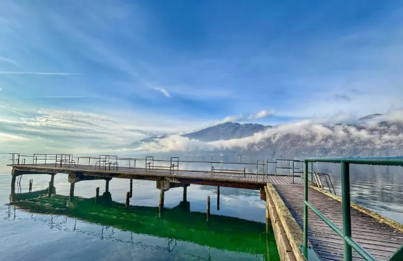 Un ponton de bois s'avance sur le lac du Bourget, les montagnes en arrière-plan