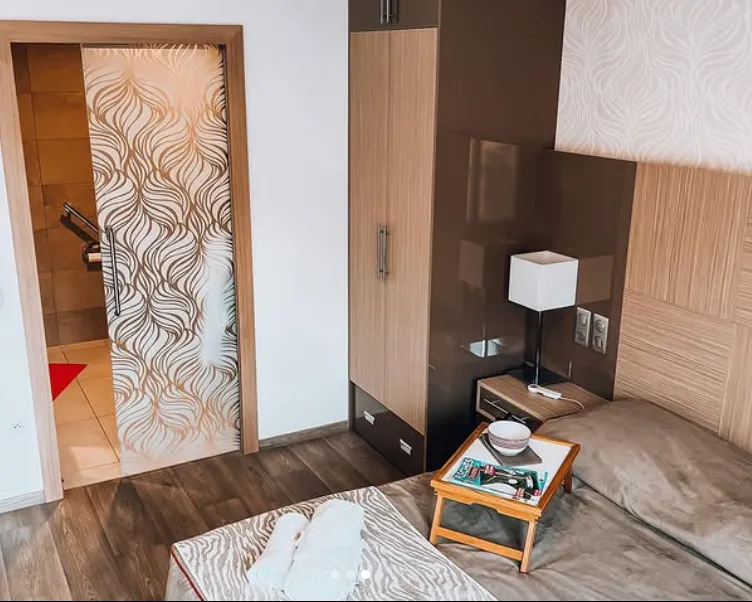 L'entrée et le coin nuit d'un appartement, avec placard, lampe de chevet et table basse