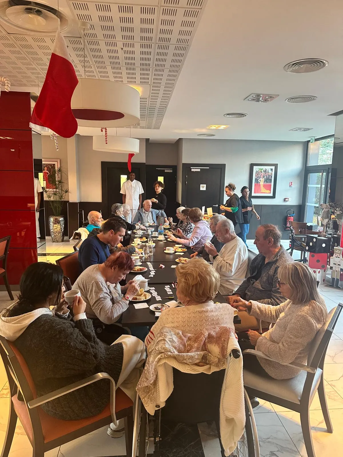 La salle à manger remplie de résidents dégustant les gâteaux à leurs tables