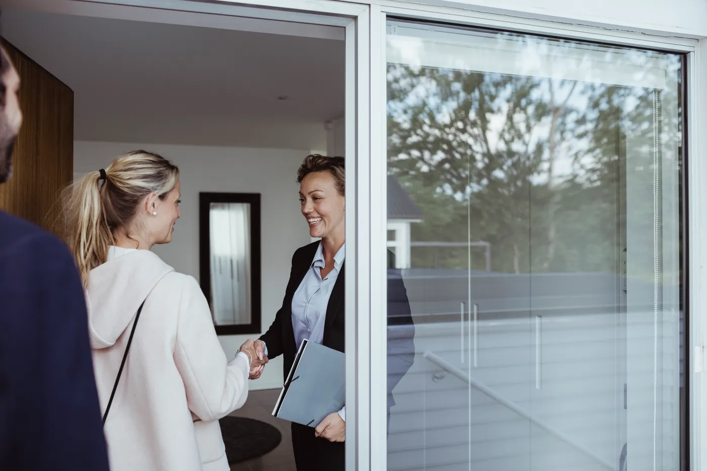 Une membre de l'équipe accueille des visiteuses sur le pas de la porte d'un appartement