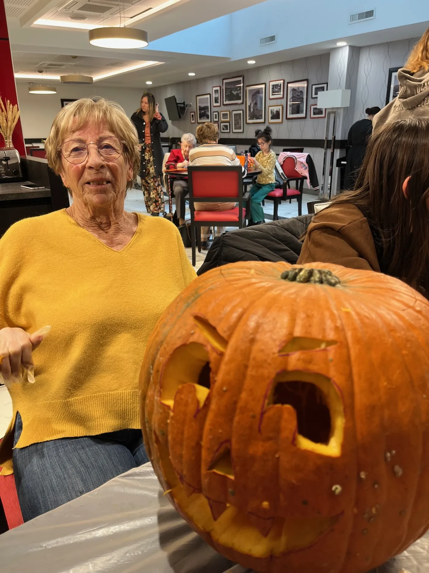 A resident sitting beside the jack-o'-lantern she has just finished carving