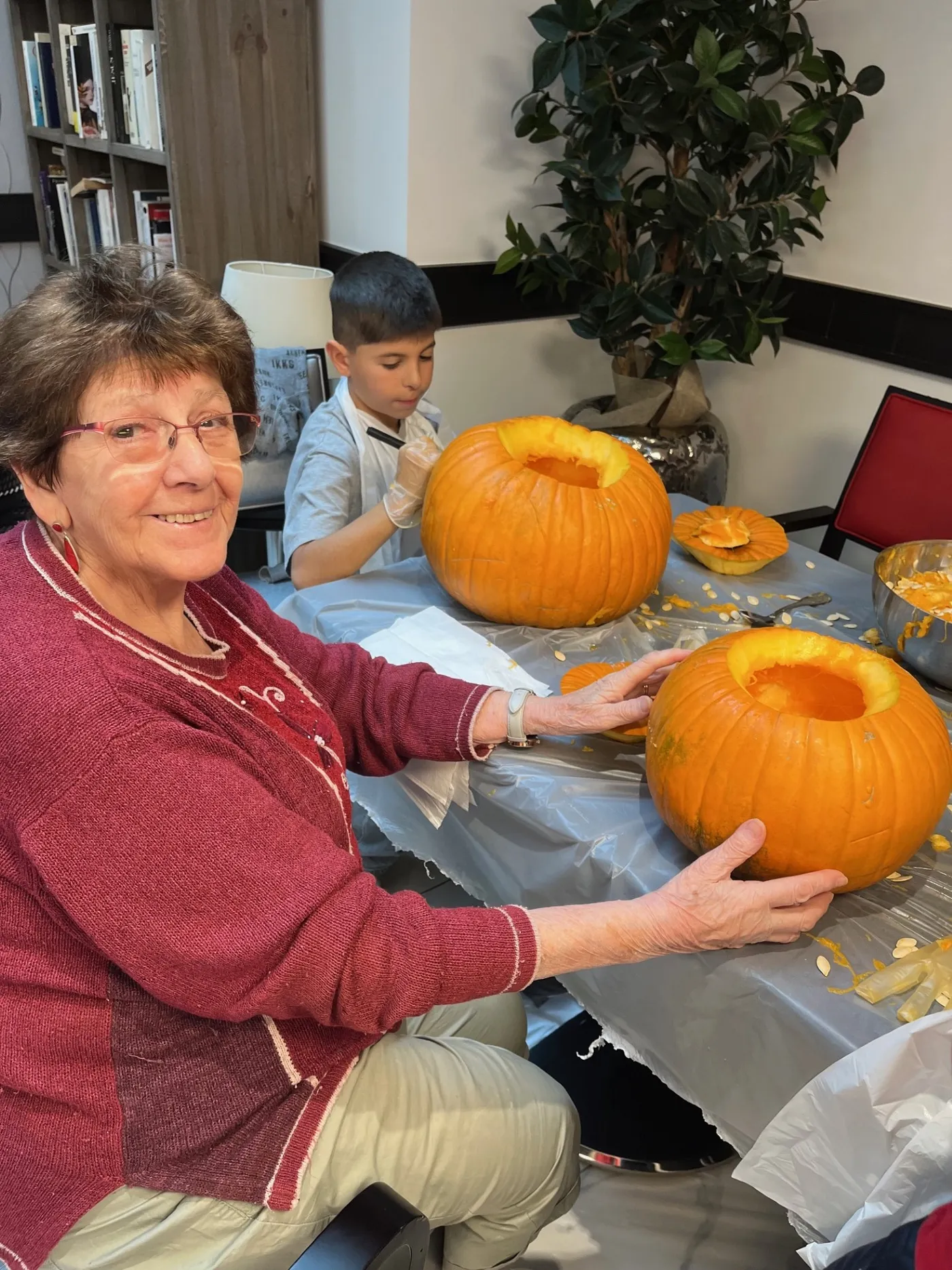 A resident and a child showing the two pumpkins they have hollowed out