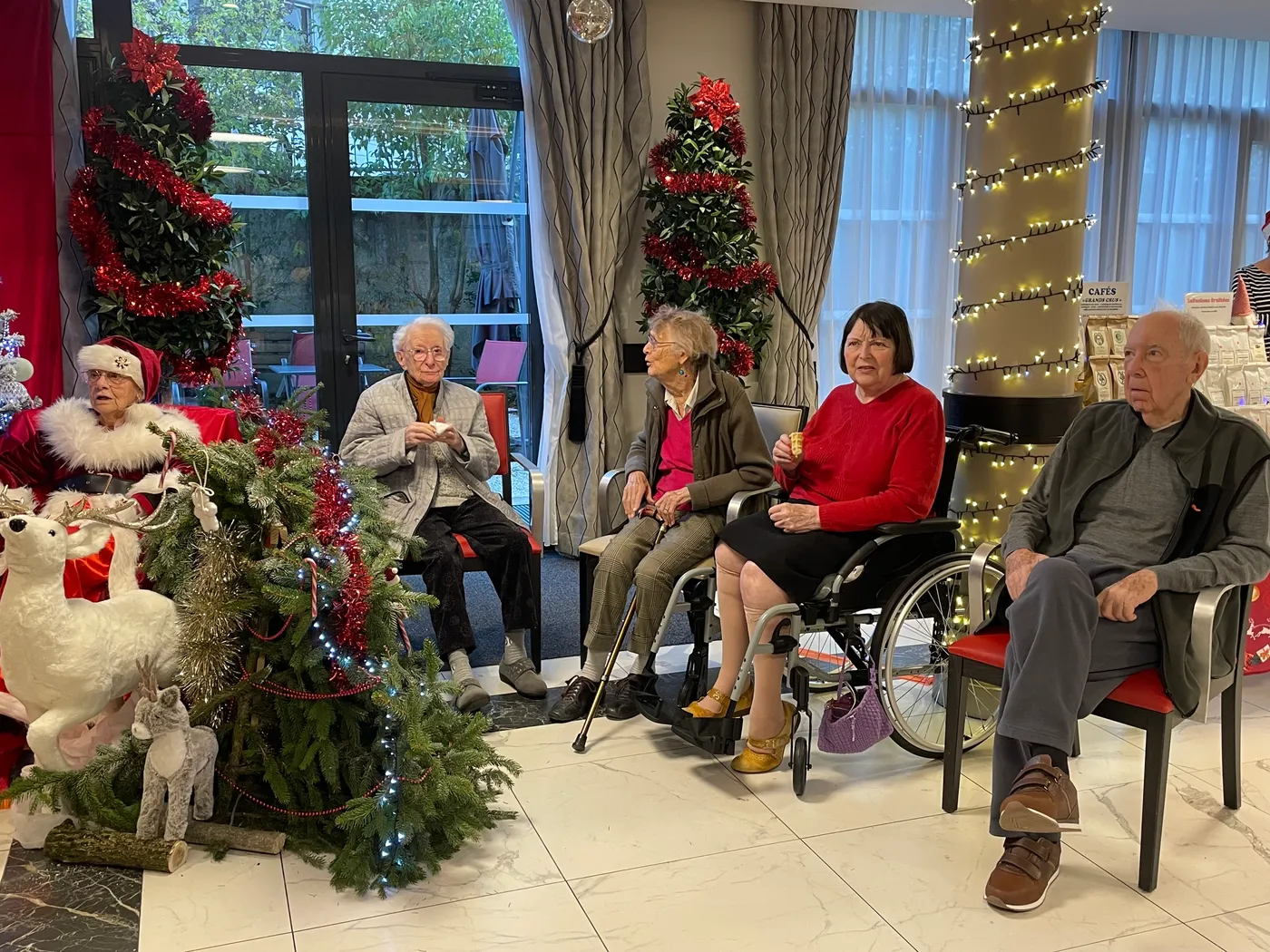 Residents seated in a row listening to the carols beside the Christmas tree