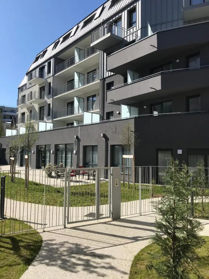 The modern black and white facade of the Chambery residence and its garden path