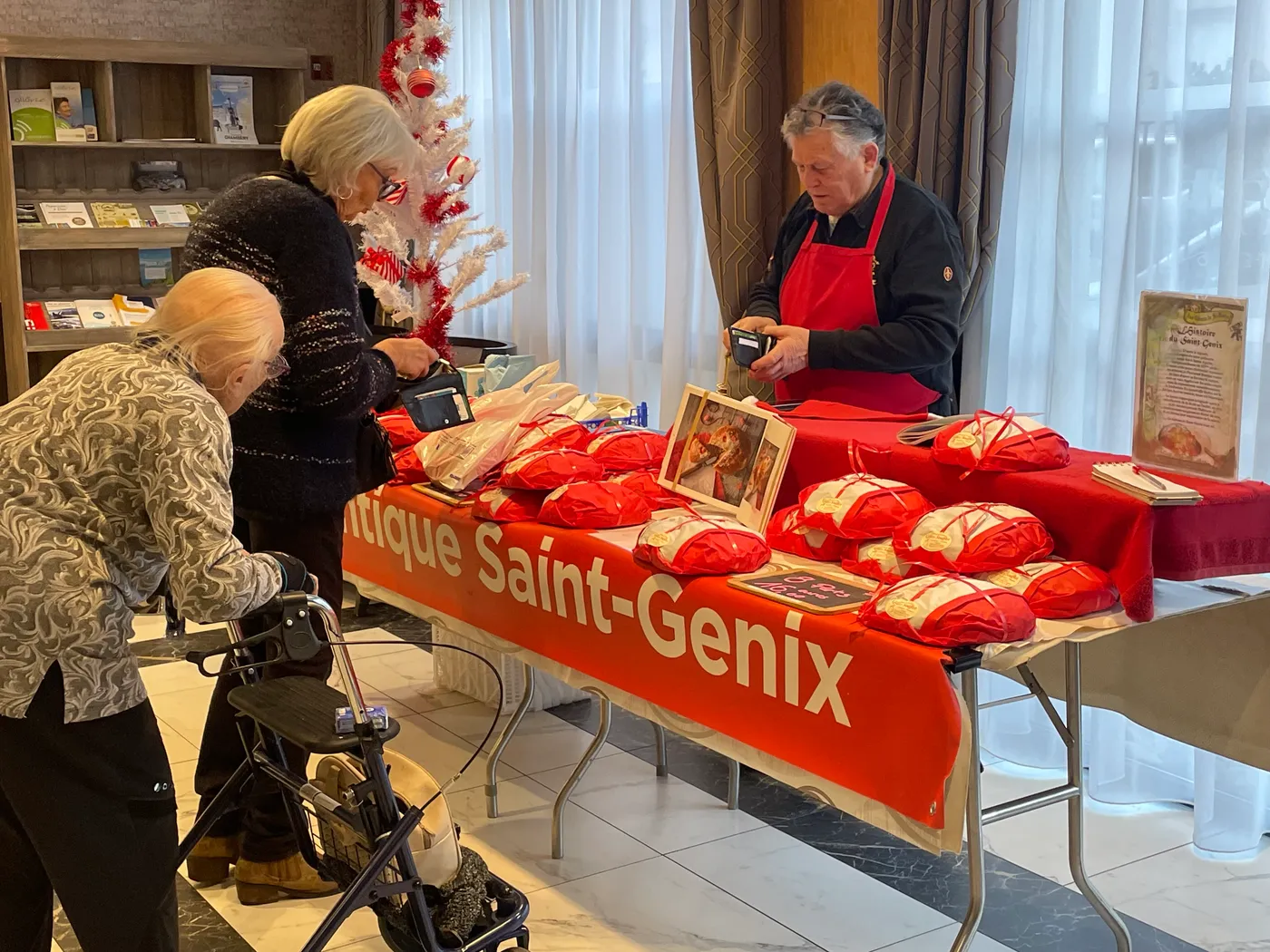 Residents at the Saint-Genix brioche stall, its red cloth piled with bagged cakes