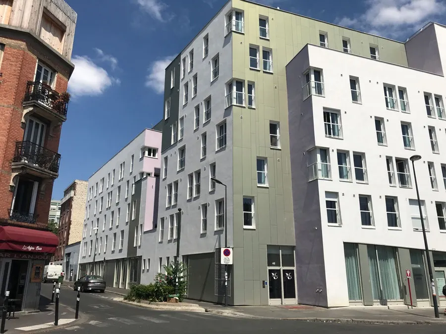 Un immeuble moderne à l'angle d'une rue de Montreuil, sa façade verte et blanche au soleil