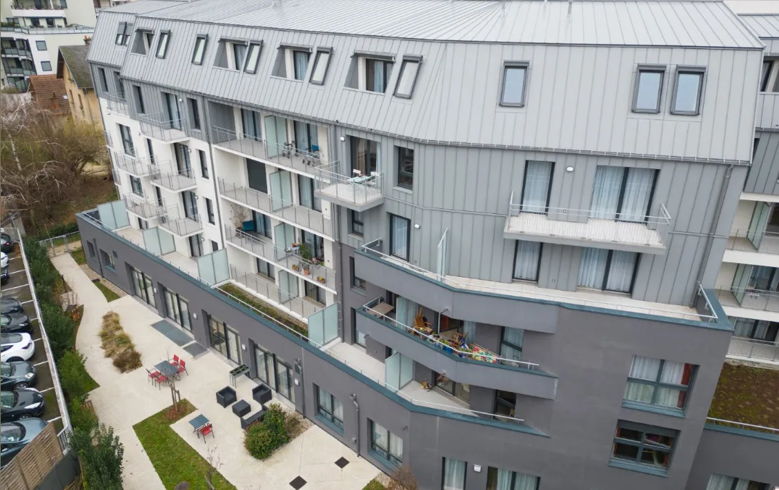 La résidence vue d'un étage supérieur, ses balcons donnant sur la cour paysagère