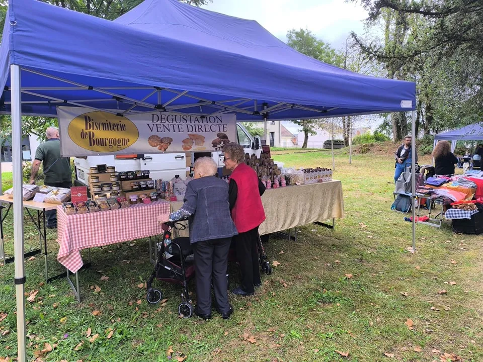 Le stand d'un producteur local sous un barnum bleu, proposant dégustation et vente directe