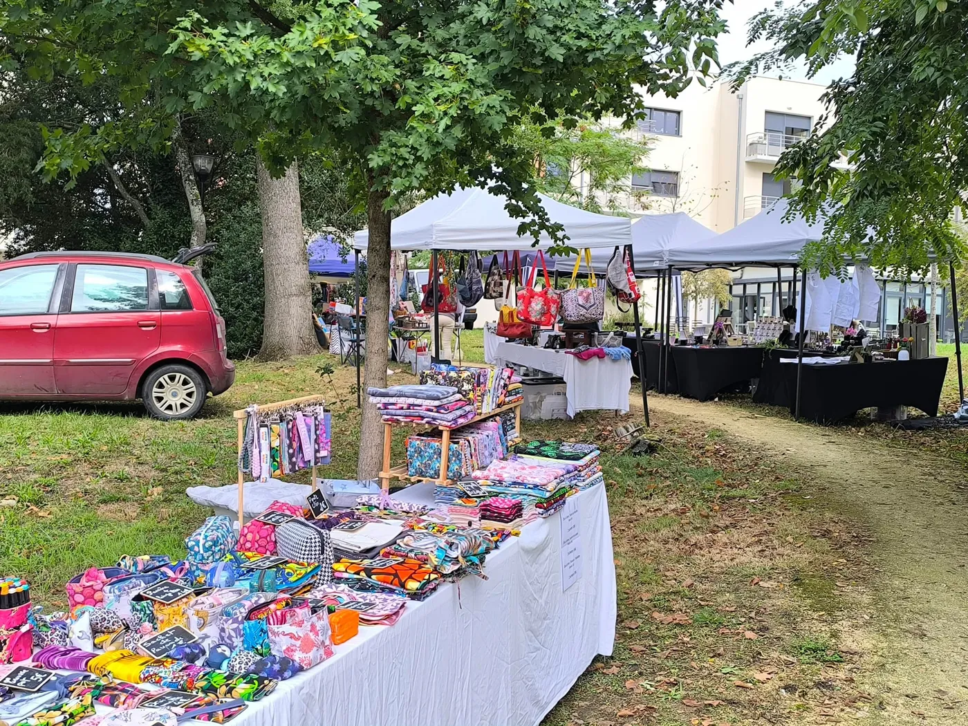 Les étals de la brocante déployés sous les arbres, les tables couvertes de bric-à-brac