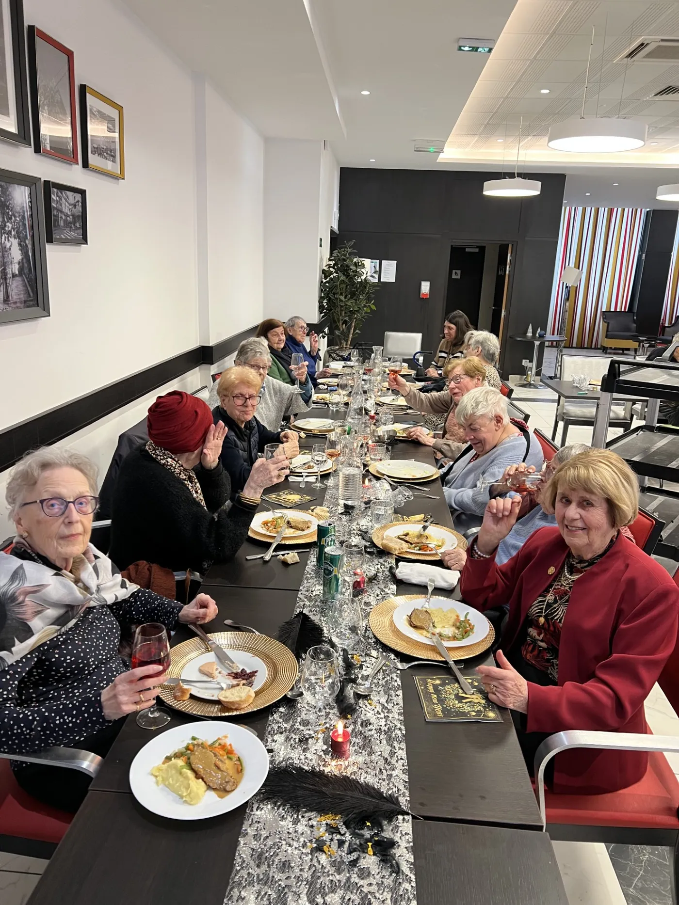 Diners lined along the festive table, plates and gold chargers in front of them
