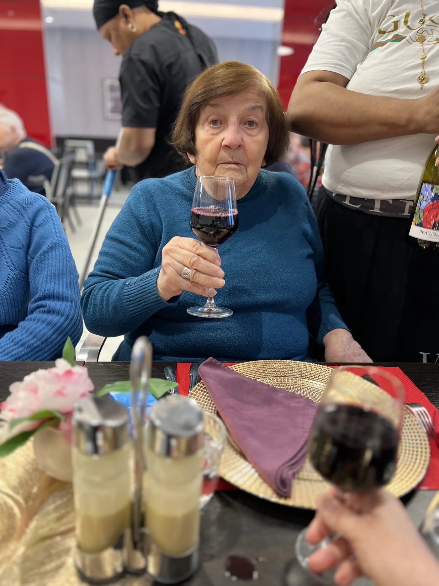 A resident raising her glass of red wine to the camera