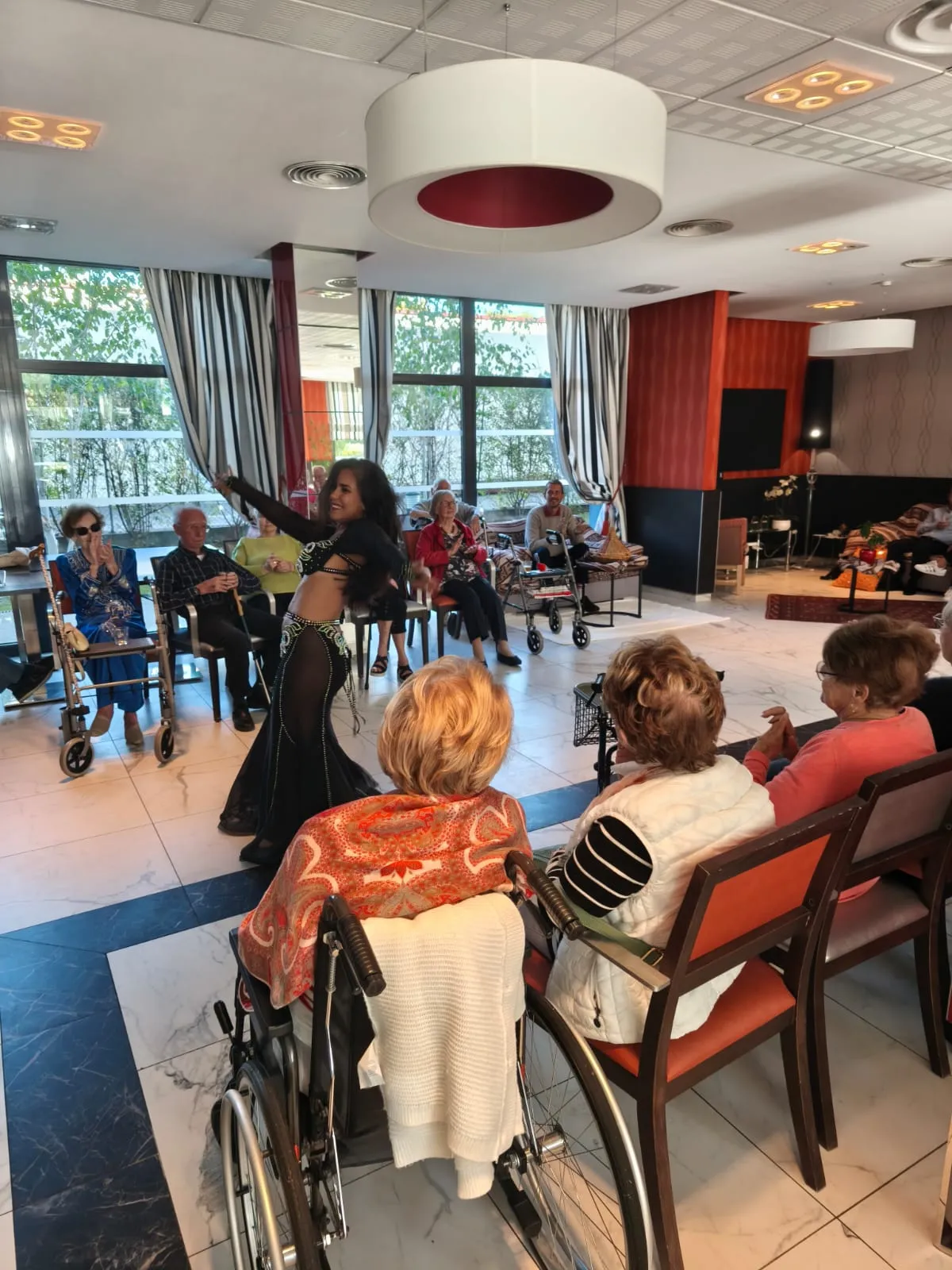 Residents watching from their chairs as a dancer performs in the lounge