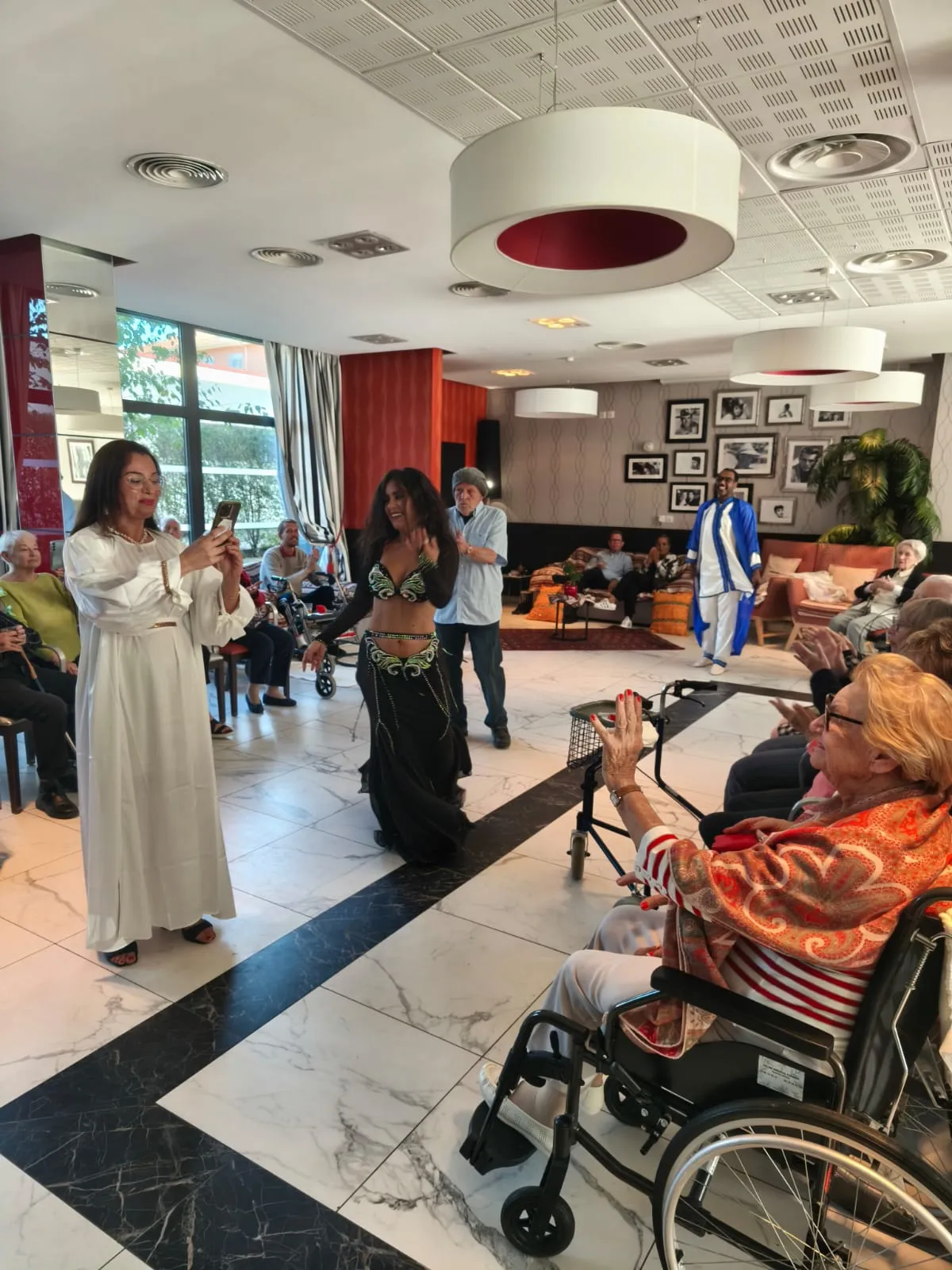 A dancer in a white gown performing in front of the seated residents
