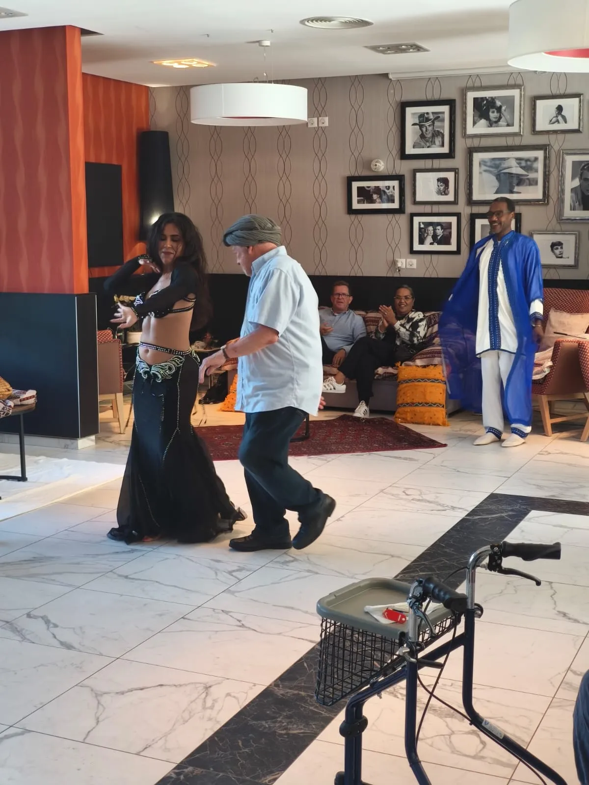 A dancer in a long gown leading a resident across the floor