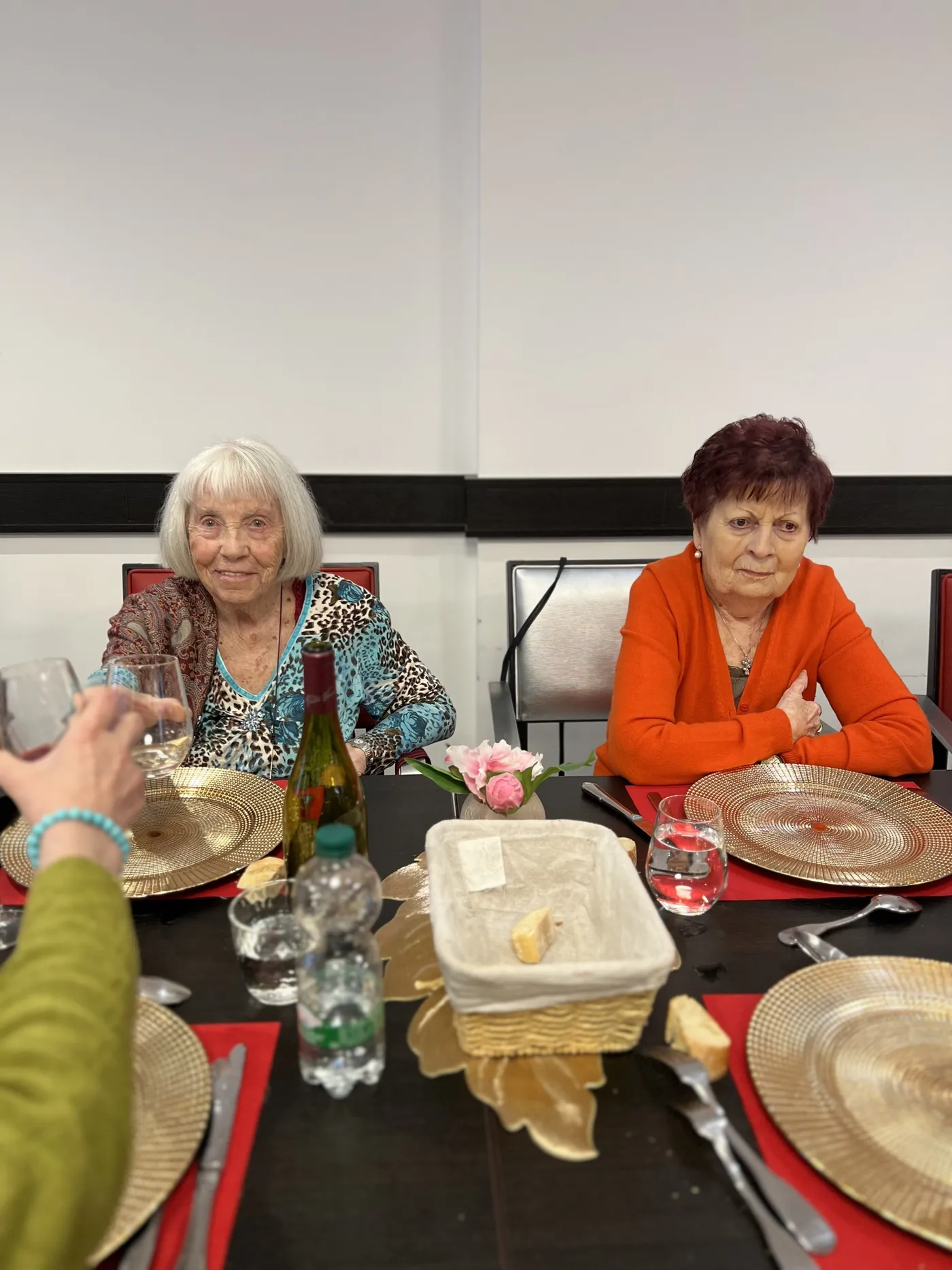 Deux résidentes à table tandis qu'un verre leur est tendu