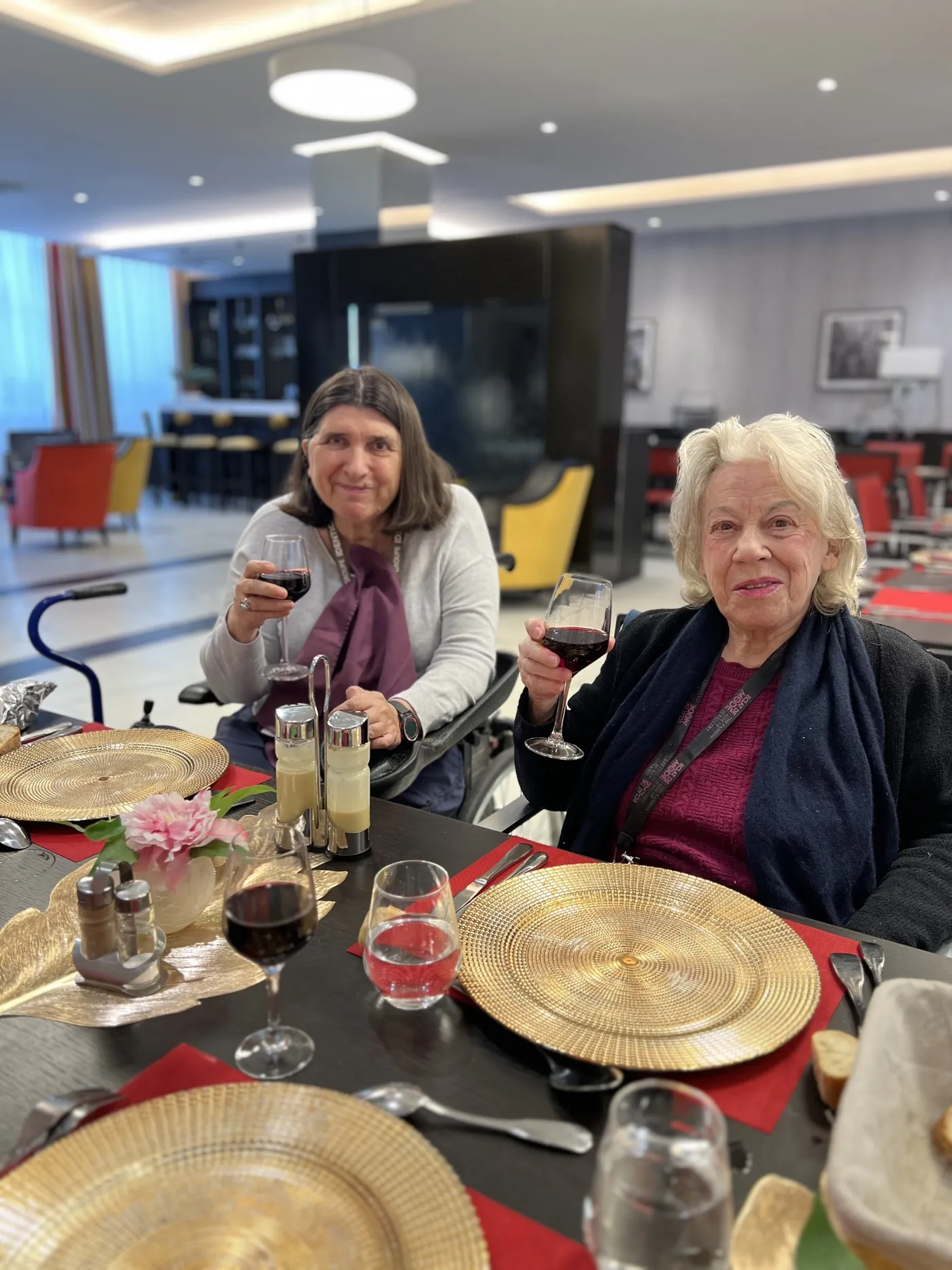 Deux résidentes lèvent leurs verres de vin rouge à table