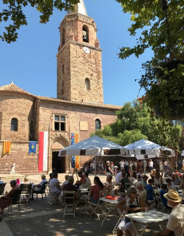 Le clocher de la cathédrale de Fréjus au-dessus des terrasses de café de la place
