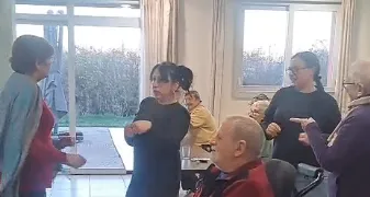 Membres de l'équipe et résidents debout dans le salon pendant la soirée