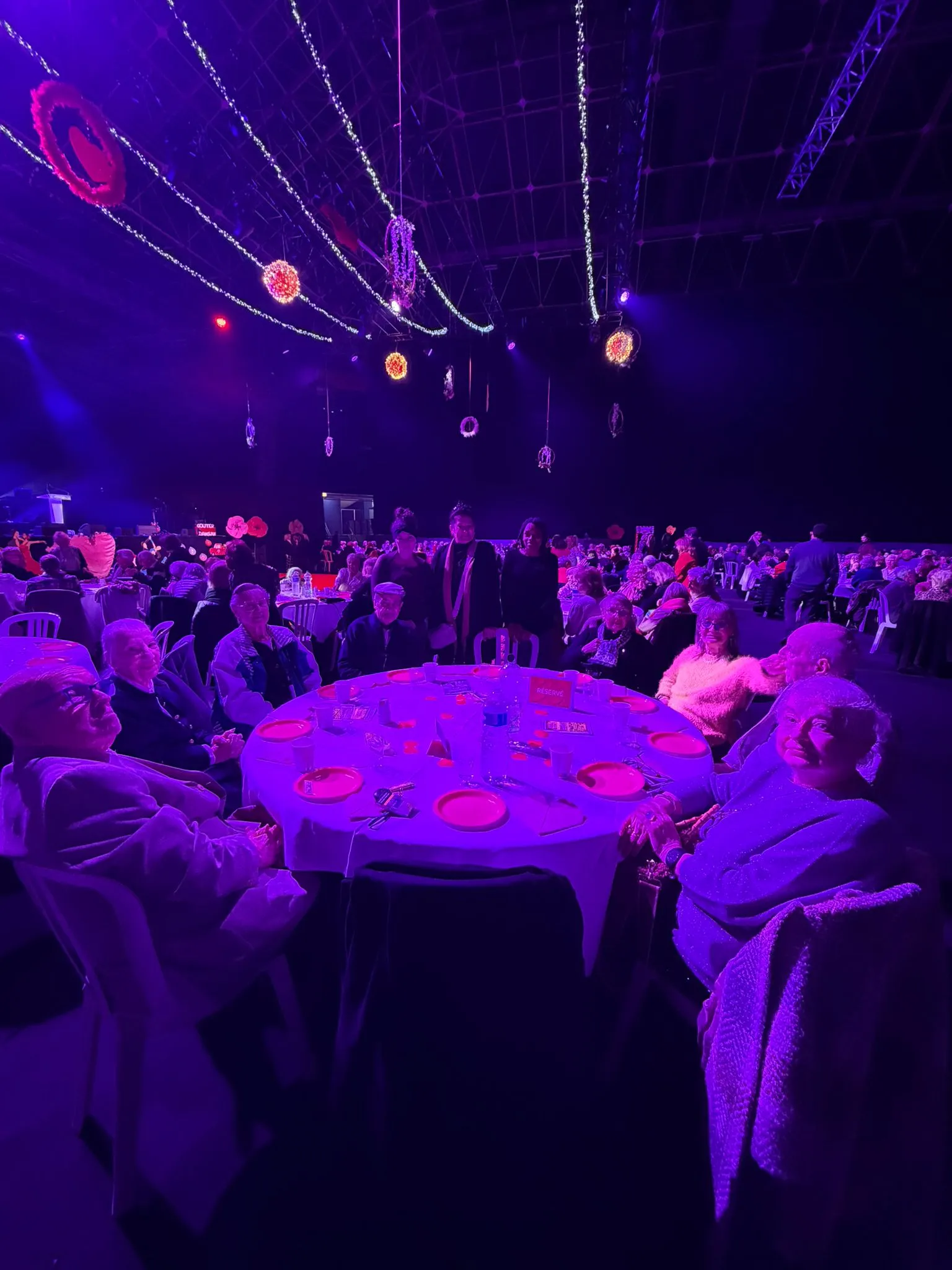 Résidents de OBEO Le Cannet attablés lors d'une grande soirée festive de la Saint-Valentin dans une salle événementielle décorée