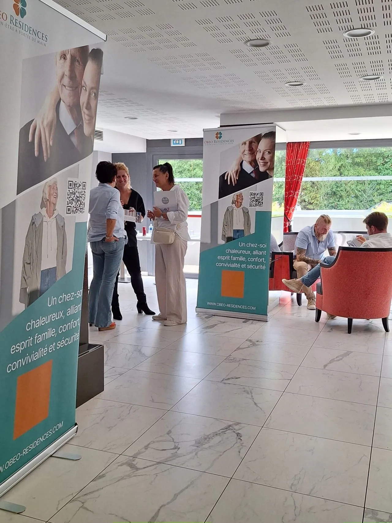 Visitors arriving between the OBEO roll-up banners in the residence lobby