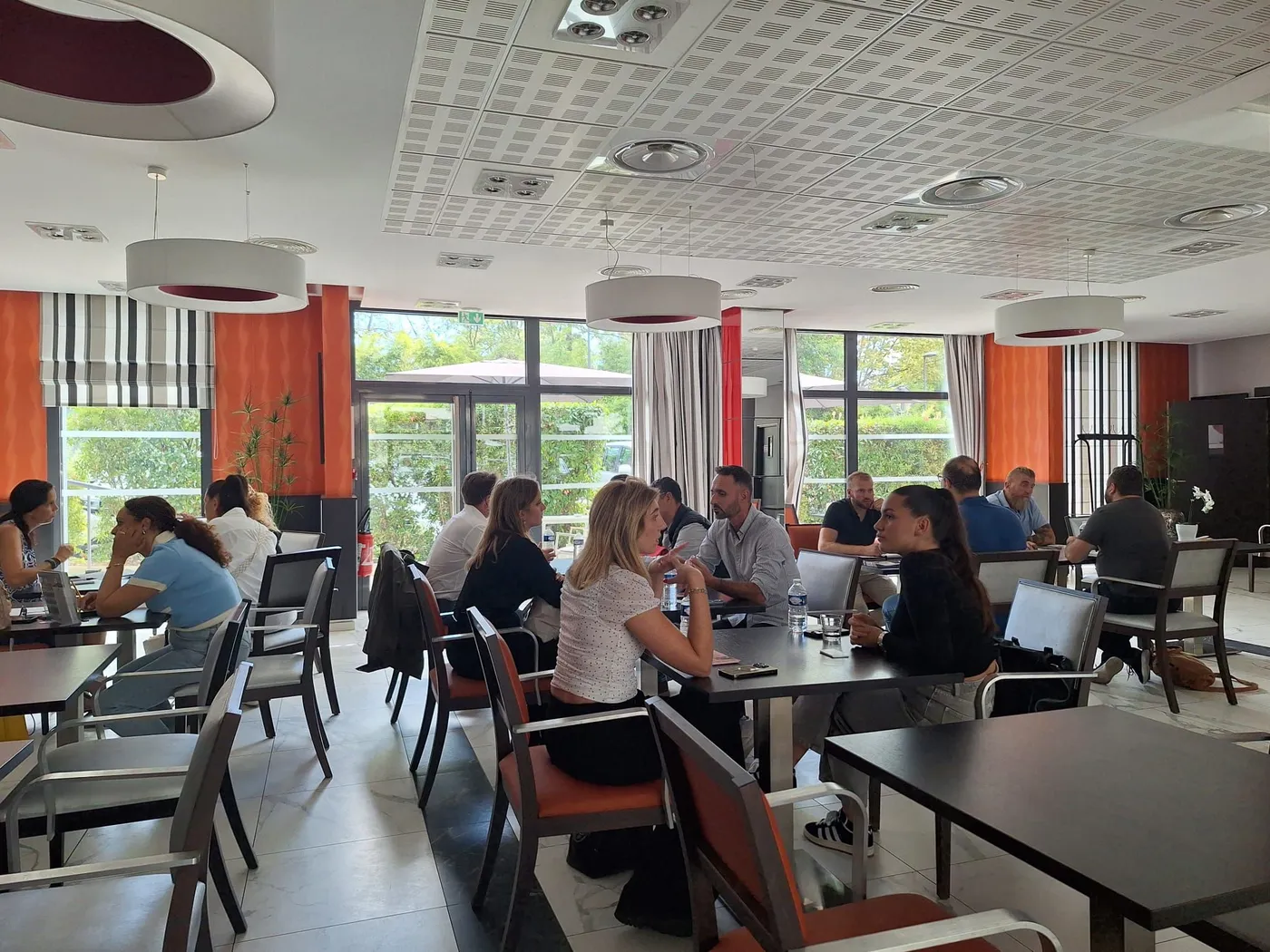 Professionals meeting at tables along the windows of the dining room