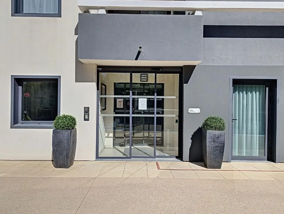The glazed entrance of the residence between two large planters