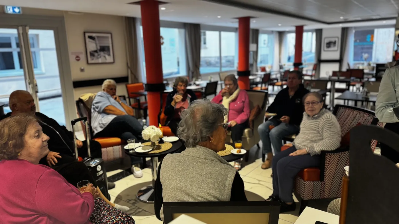Des résidents réunis au salon, des tasses de café posées sur les tables basses