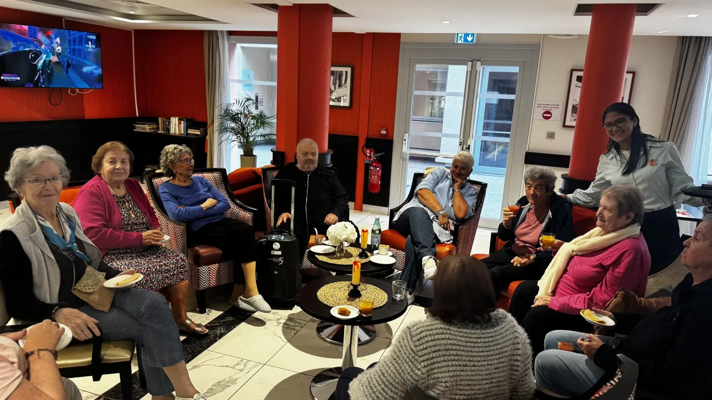 Des résidents bavardent autour d'un café dans le salon