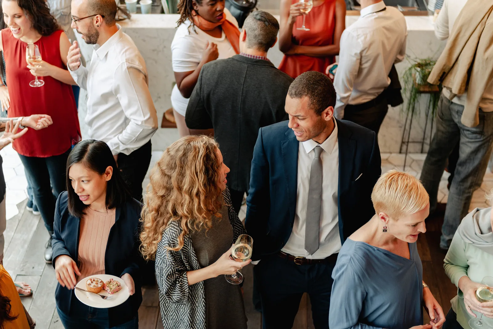Professionals talking over a drink at an informal networking gathering.